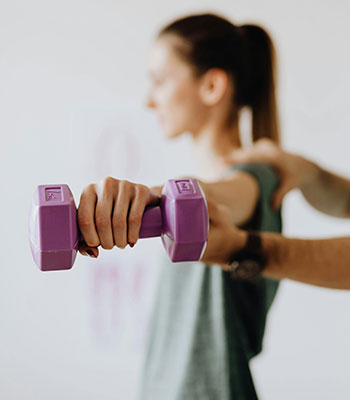 Woman lifting a weight in physical therapy
